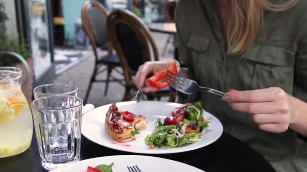 Női kézzel vágott egy szelet pizza egy tányérra egy hangulatos utcai kávézóban. — Stock videók