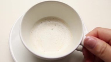 Beyaz bir masa üzerinde latte ile beyaz seramik fincan