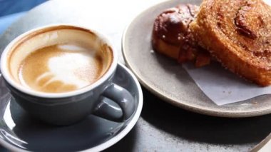 Masada latte kahve ile taze vegan şeker tarçın rulo. Yukarıdan görüntüle.