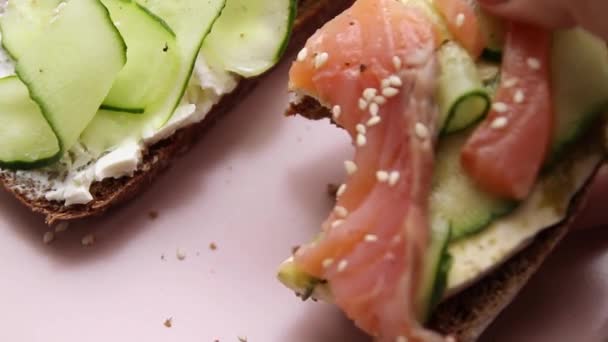 Sandwich abierto con pescado y verduras con plato de cerámica rosa — Vídeo de stock