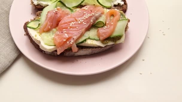 Sandwich ouvert aux poissons et légumes avec assiette en céramique rose — Video