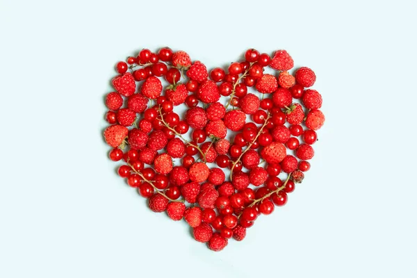 Forma de corazón frutas de bayas surtidos sobre fondo azul . — Foto de Stock