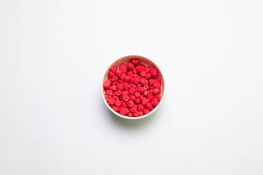 Beyaz bir masada gri bir kapta taze olgun ahududu.