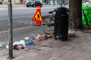 Sokakta çöp ve çöp dolu demir çöplük yakınında plastik veya naylon çöp torbaları