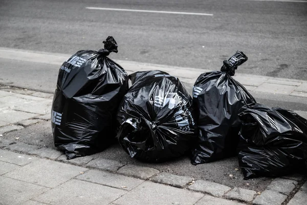 Pilha de lixo preto no caminho na estrada lateral na cidade grande, lixo poluição — Fotografia de Stock