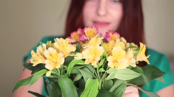 Floristería femenina pone flores en un jarrón de vidrio — Vídeo de stock