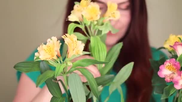 Female florist puts flowers in a glass vase — Stock Video