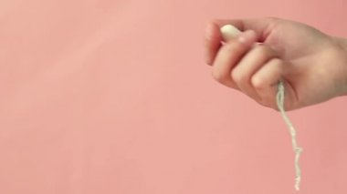 Kadın el pembe bir arka plan üzerinde bir tampon gösterir.