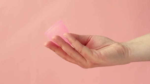 Kobieta ręka trzyma wielokrotnego użytku silikonowy kubek miesiączkowy. Zero odpadów koncepcja miesiączki. — Wideo stockowe