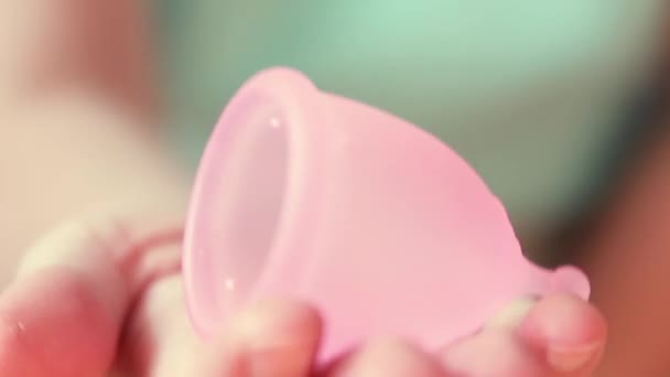 Vue rapprochée de la jeune femme tenant une coupe menstruelle. Produit d'hygiène féminine alternatif pendant la période . — Video