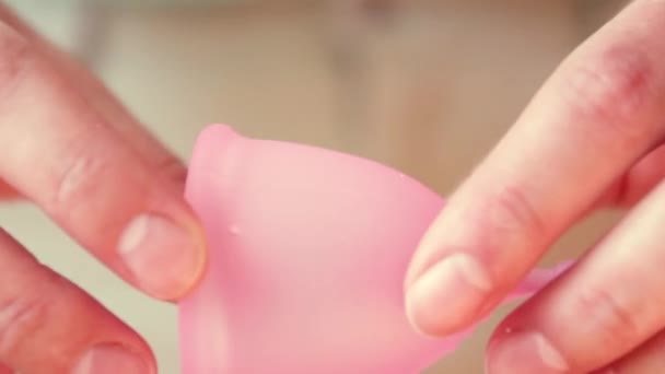 생리컵을 접는 젊은 여성의 손을 클로즈업. 중요한 날, 생리의 개념 — 비디오