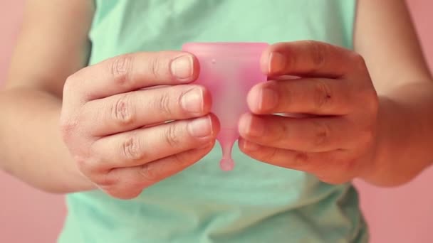 Gros plan des mains de la jeune femme pliant une coupe menstruelle — Video