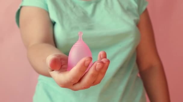 Vista de cerca de una mujer joven sosteniendo una taza menstrualProducto alternativo de higiene femenina durante el período . — Vídeos de Stock