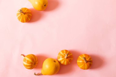 Pembe arka plan üzerinde küçük kabaklar ve ışıltı dekor Halloween kompozisyon. Metin için yer.