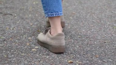 dans eden kızlar kot pantolon ve spor ayakkabı asfalt şehrin arka planda bacaklar.