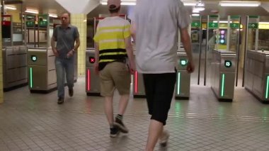 İnsanlar istasyondaki turnikelerden metroya giriyorlar. Yeraltı taşımacılığında ödeme sistemi.