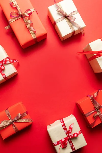 Composición navideña con cajas de artesanía roja festiva y patrón de cintas rojas . — Foto de Stock