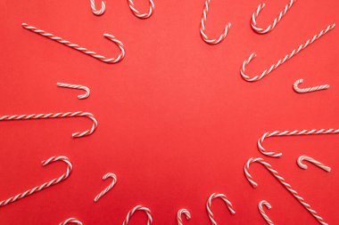 Kırmızı arka planda şeker kamışı çerçeveli mutlu noel afişleri. Şablon düzenleme tebrik kartı