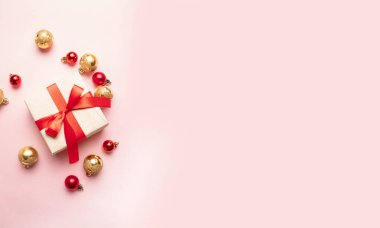 Şimdiki kutulu Noel arkaplanı, pembe arka plan manzaralı tatil süslemeleri. Web sitesi için tatil afişi. Düz konum biçimi kompozisyonu, üst görünüm