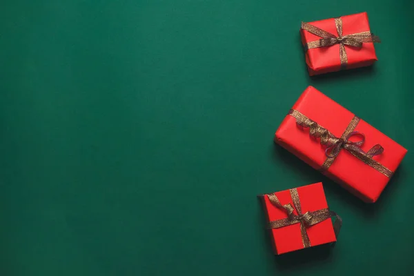 Banner de Navidad. Diseño de fondo de Navidad con caja de regalo roja artesanal con cinta de oro sobre fondo verde — Foto de Stock