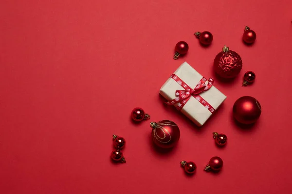 Composición creativa con regalos o presenta cajas con lazos rojos, bolas rojas sobre fondo rojo . —  Fotos de Stock