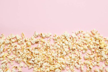 Pembe arka planda patlamış mısır deseninin üst görüntüsü. Sinema, sinema ve eğlence konsepti.