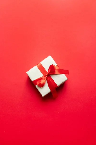 Concepto de Año Nuevo mínimo. Composición navideña con caja de artesanía roja festiva y cinta roja — Foto de Stock