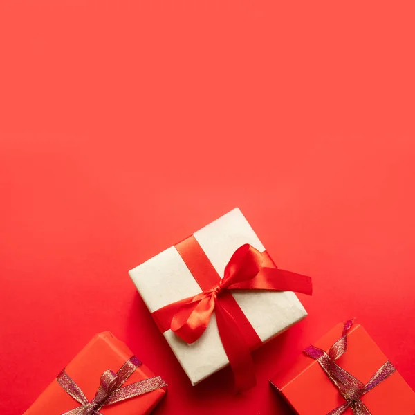 Cajas de regalo artesanales de Navidad en vista superior de fondo rojo. Tema vacaciones de invierno . — Foto de Stock