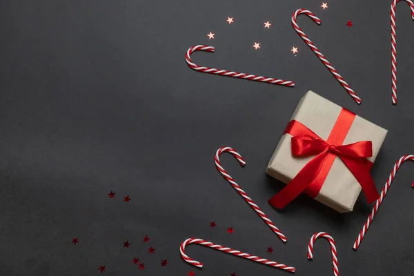 Újév. Noel vagyok. Karácsonyi ajándék és szív cukornád egy piros háttér felülnézet. Téli karácsonyi ünnepi téma. Lapos fektetés — Stock Fotó