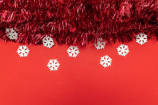 Weihnachtskomposition mit Lametta auf rotem Hintergrund. Weihnachten, Winter, Neujahrskonzept. flache Lage, Draufsicht, Kopierraum. — Stockfoto