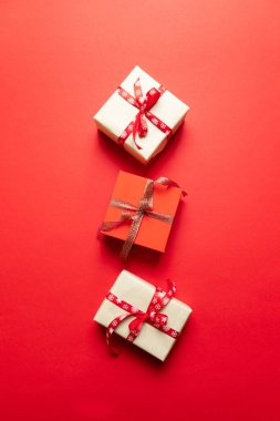 Altın yıldızlı hediye kutusunun yaratıcı kompozisyonu, kırmızı arka planda toplar. Düz konum, üst görünüm, kopyalama alanı