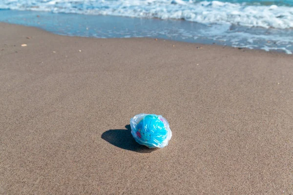 Planet ball in a plastic bag on the sea. Environmental pollution concept.