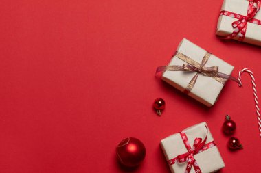 Süpriz el sanatları kutuları, kırmızı bant yayları ve klasik kırmızı cam süslemeler yatay kenar topları ile Noel süslemeleri.