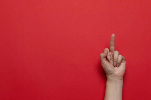 Woman hand showing middle finger on a red background. Flat lay style composition — Stock Photo, Image