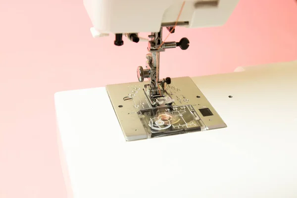 Primer plano de una máquina de coser sobre un fondo rosa — Foto de Stock