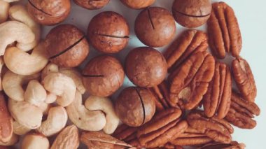Gri arka planda çeşitli macadamia, kaju ve Brezilya fındıkları üst görünümü, yakın, düz yatar