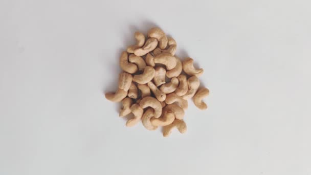 Ovanifrån av rå cashewnötter på en grå bakgrund, platt låg — Stockvideo