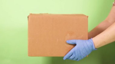 İnsan eli, bir müşteriye bir karton kutu verir. Coronavirus karantina salgını sırasında paket ve paketlerin evde teslimi