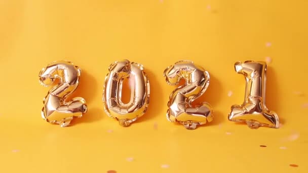 Globos de aire de lámina dorada sobre fondo amarillo. Feliz año nuevo 2021 celebración de vídeo . — Vídeos de Stock