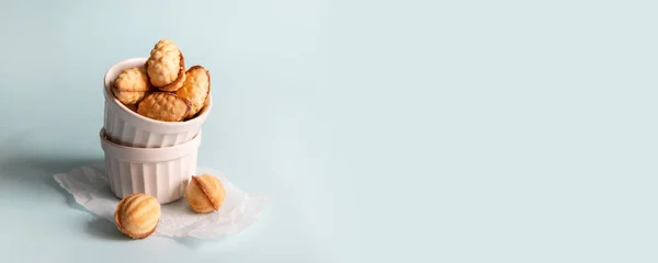 Sabrosa composición de banner con conos en forma de galletas de nuez sobre un fondo azul con espacio para copiar. Concepto de snack de comida saludable — Foto de Stock