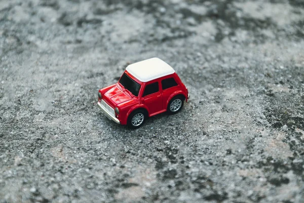 Transportation and travel concept. Red retro car toy model on the road