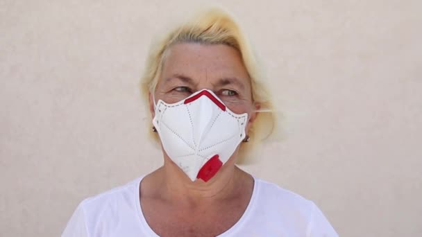 Oude blanke vrouw met masker FFP3 met uitademingsventiel. Bescherming tegen virus, infectie, uitlaat — Stockvideo