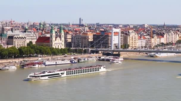 Boedapest is de hoofdstad van Hongarije. Een grote boot met toeristen drijft op een zonnige dag over de Donau — Stockvideo