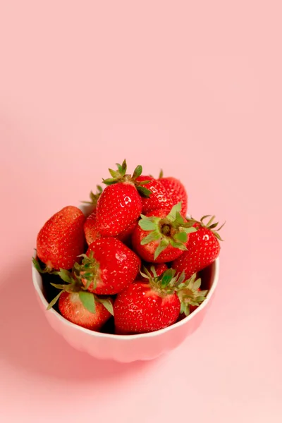 Schüssel mit frischen Erdbeeren auf rosa Hintergrund. Sommer Komposition, vertikales Foto — Stockfoto
