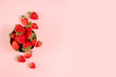 Pembe arka planda organik ve lezzetli çilek çerçeveli üst manzara