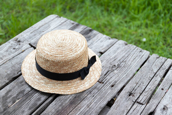 straw hat on a wooden table in the garden