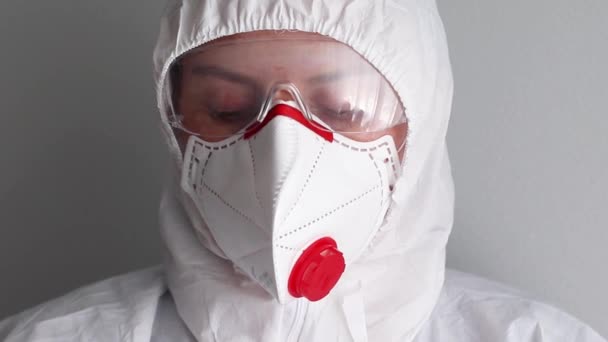 Zblízka tvář ženy v ochranné zdravotnické uniformě, brýle a obličejová maska během pandemie koronaviru. — Stock video
