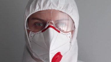 Gözlüklü ve koruyucu maskeli bir kadın doktor kameraya bakıyor. 2019 Yeni Coronavirus 2019-nKoV, COVID-19 Konsepti.