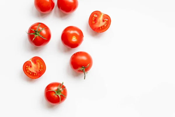 Composición alimenticia de muchos tomates rojos maduros frescos sobre un fondo blanco con espacio para copiar — Foto de Stock