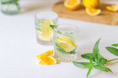 Yaz partisi için beyaz arka planda cam içinde ferahlatıcı limonata manzarası. Buzlu yaz içkileri